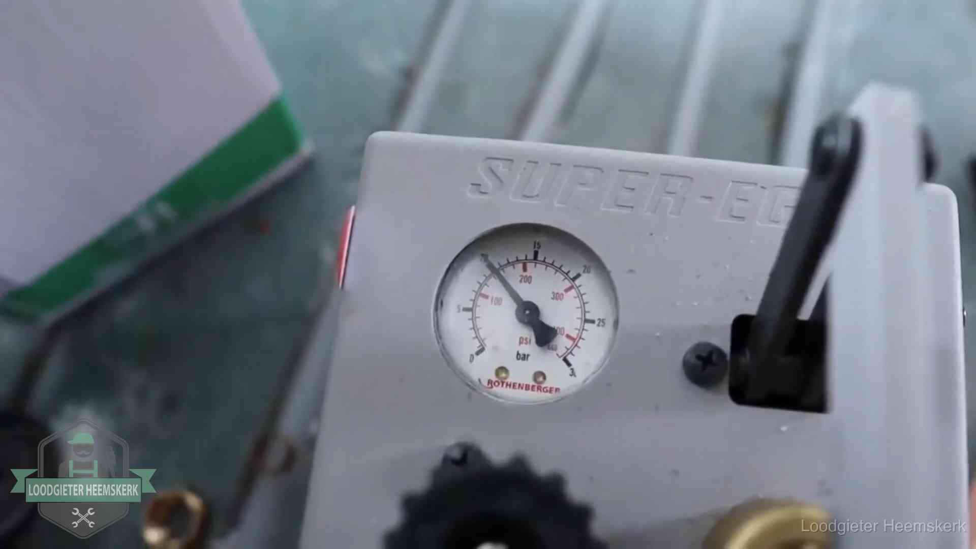Manometer van een afperspomp bij controle van nieuw leidingwerk in Heemskerk