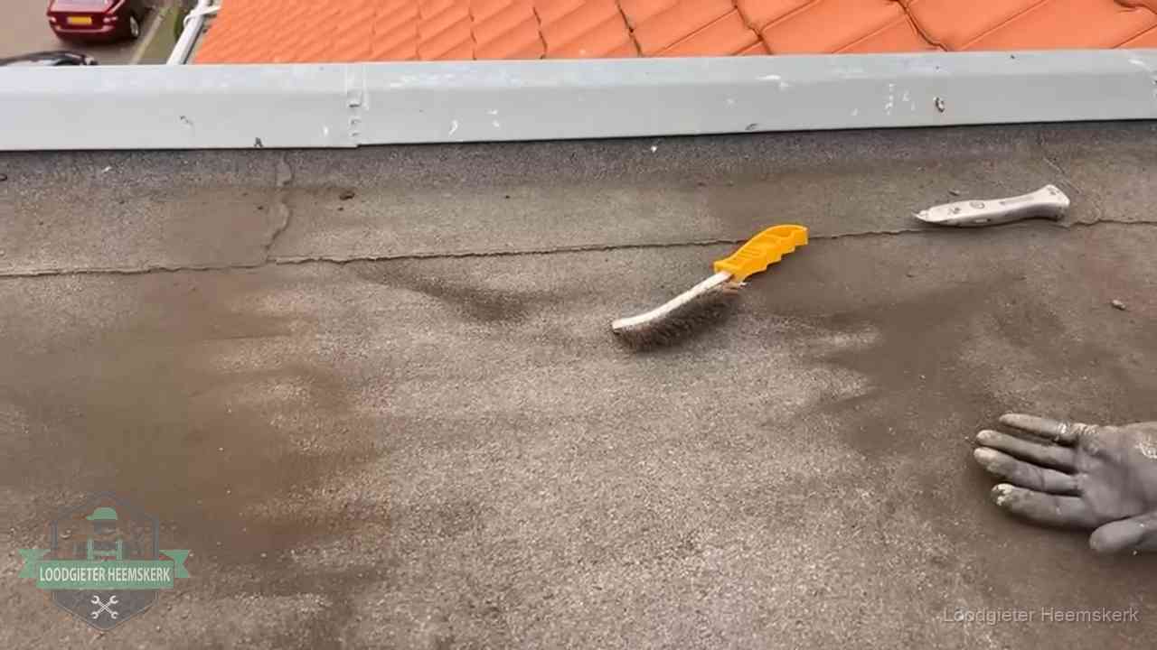 Dakdekker bereidt een bitumen plat dak voor op reparatie bij de daktrim in Heemskerk