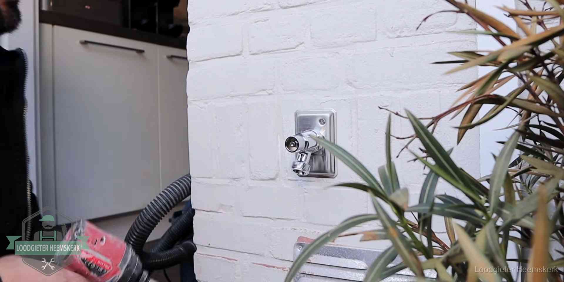 Chromen kraan op een muurplaat bij een woning in Heemskerk, dichtdraaien is stap een van de lektest