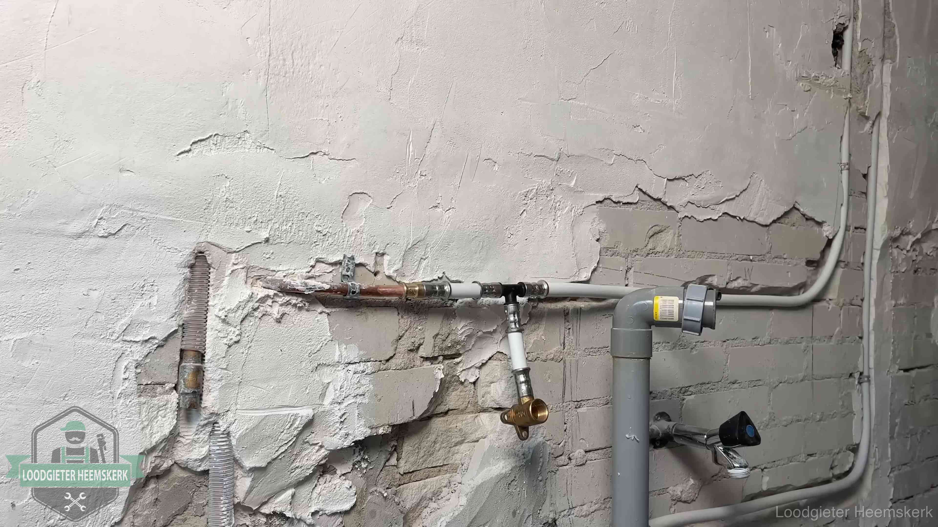 Nieuw leidingwerk naast een oud verroest leidingrestant in een woning in Heemskerk