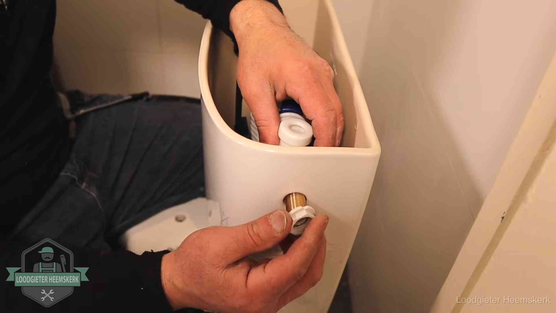 Loodgieter voor je verstopte wc in Heemskerk Loodgieter monteert de vlotterkraan van een stortbak bij een toilet in Heemskerk
