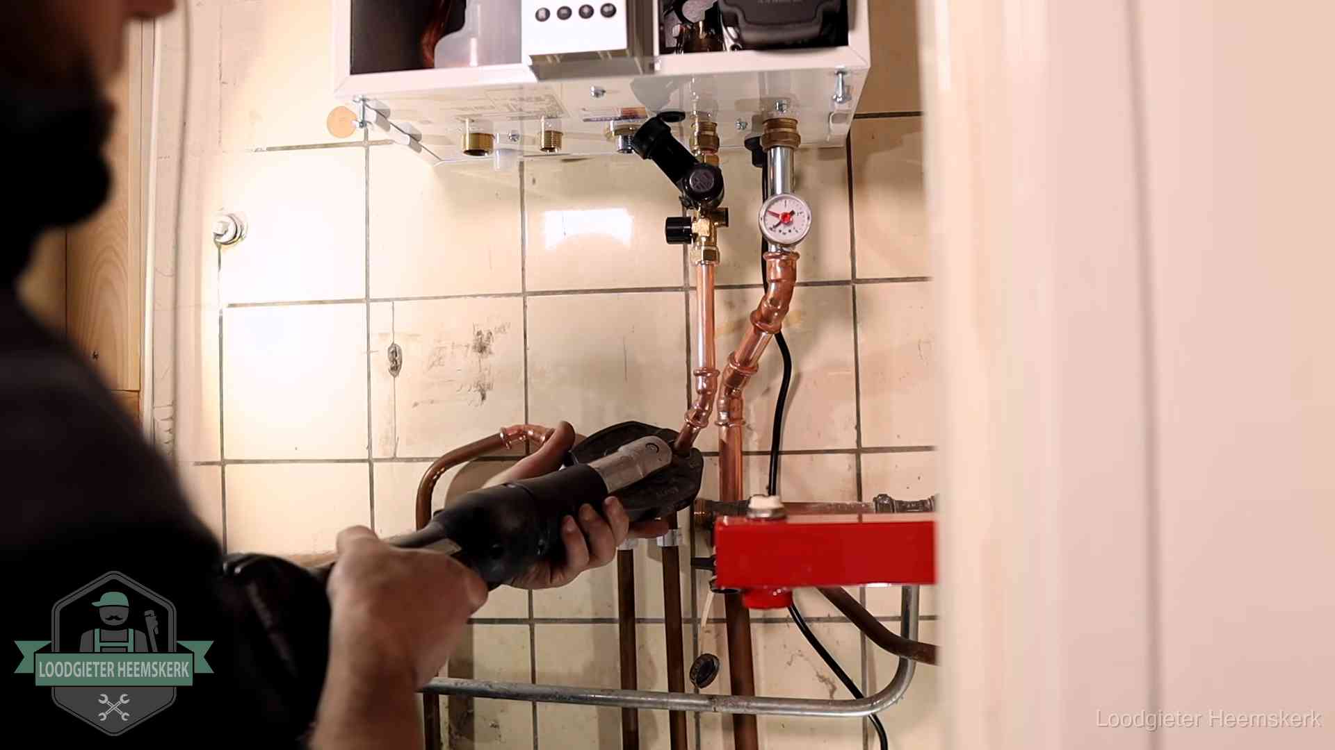 Cv-ketel onderhoud in Heemskerk Monteur werkt aan de leidingen onder een cv-ketel in Heemskerk