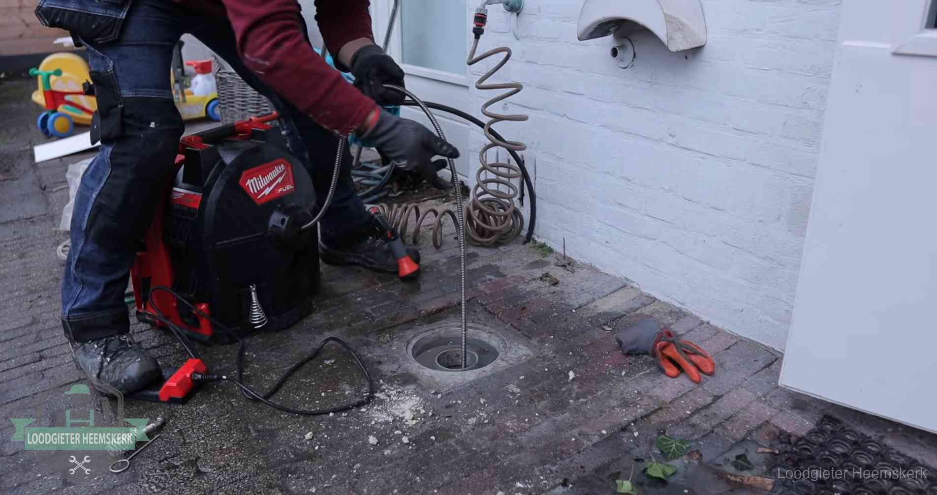 Erfgrens en gemeenteriool in Heemskerk Ontstoppingsputje in de bestrating naast de gevel van een woning in Heemskerk