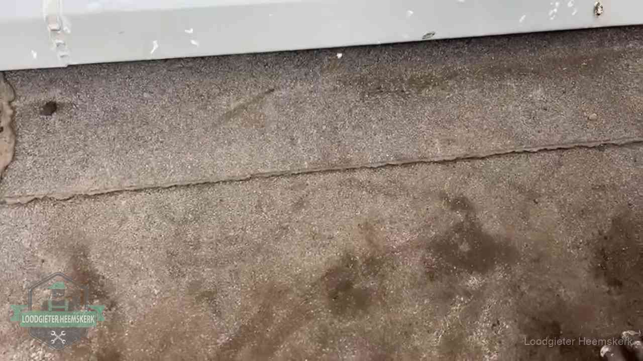 Vochtplekken bij de naad van een plat dak na aanhoudende regen in Heemskerk