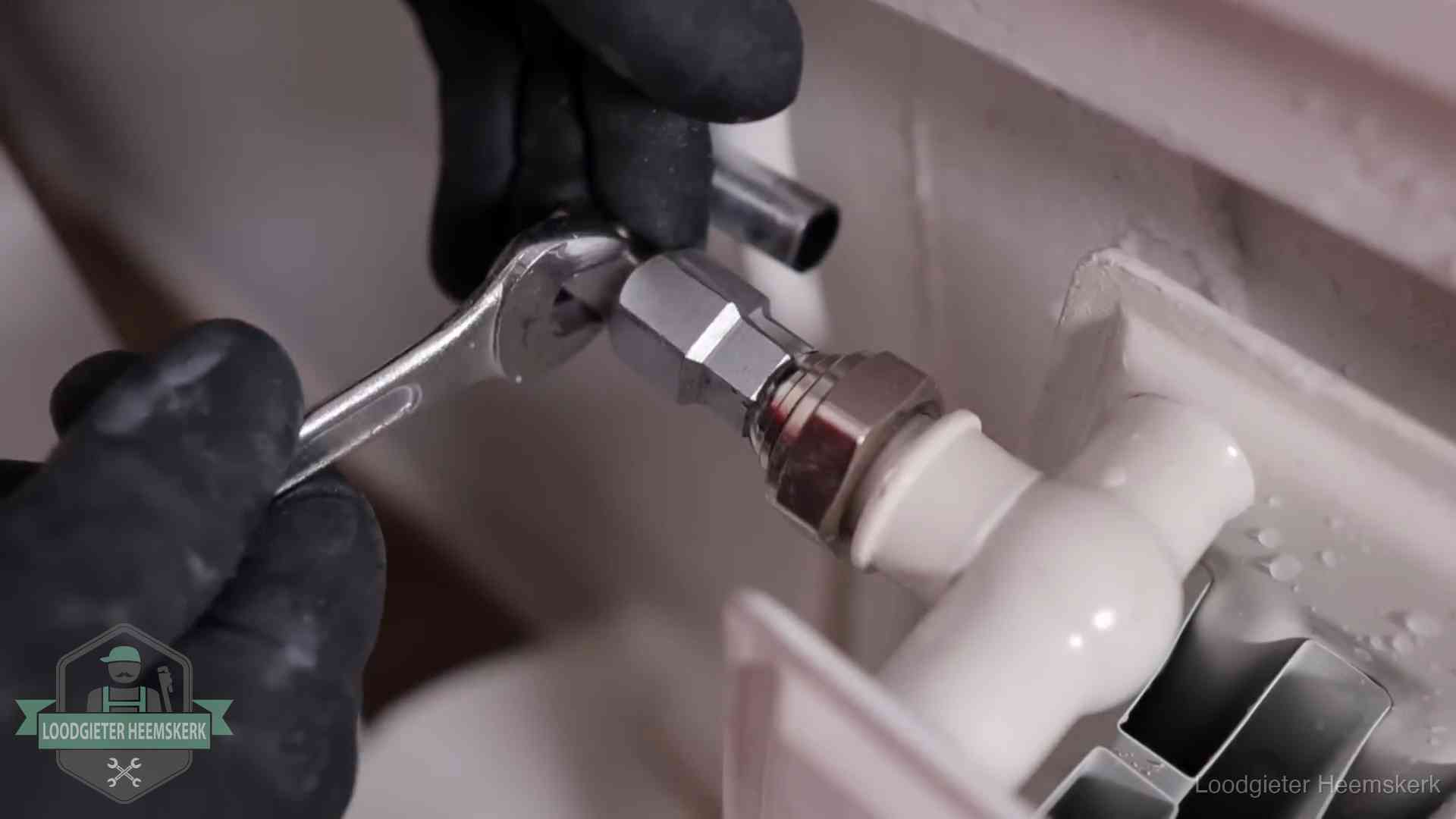 Radiatoren en waterzijdig inregelen in Heemskerk Steeksleutel draait een wartelkoppeling op een radiatorkraan aan in Heemskerk