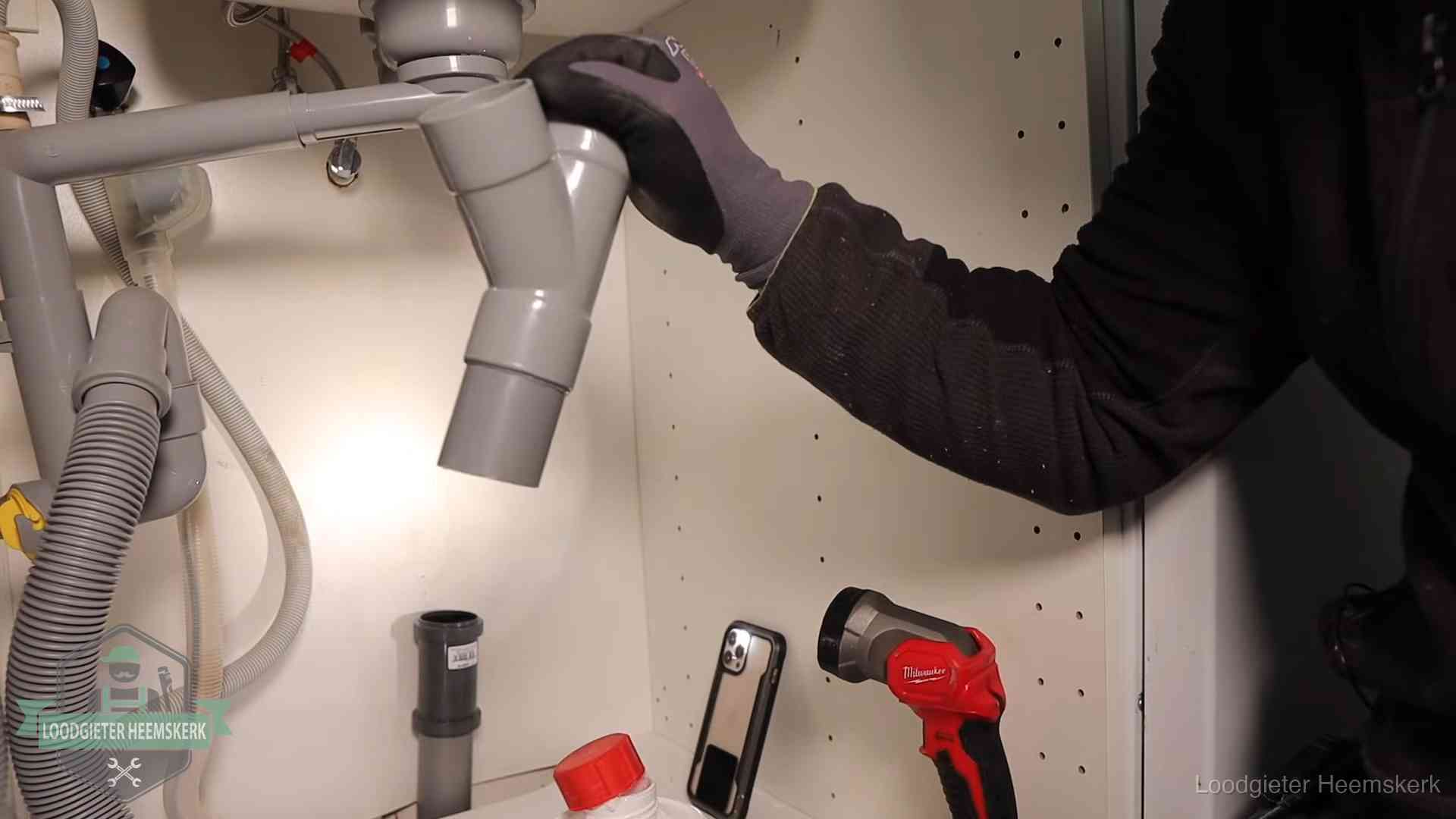 Rioollucht in huis verhelpen in Heemskerk Loodgieter demonteert het sifon- en afvoerwerk onder een gootsteen in Heemskerk bij stankklachten