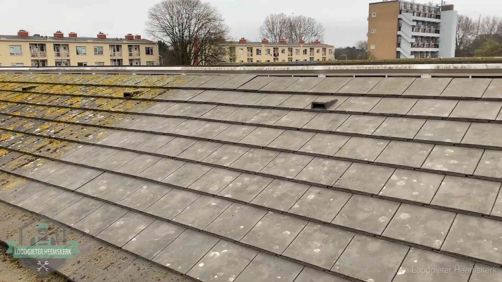 Schuin dak met betonpannen vol mos in Heemskerk, een risico op lekkage bij de pannen
