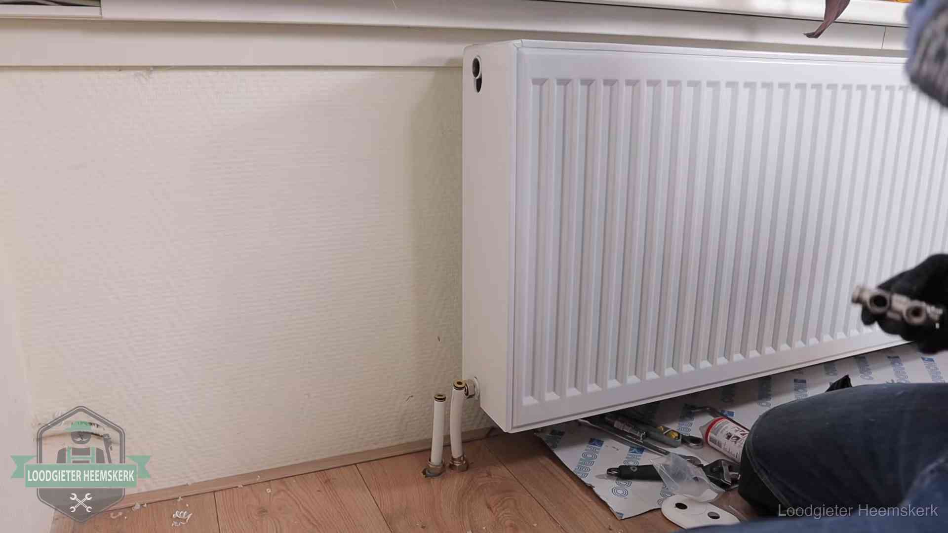 Verwarming per wijk in Heemskerk Nieuw gemonteerde radiator in een woonkamer in Heemskerk