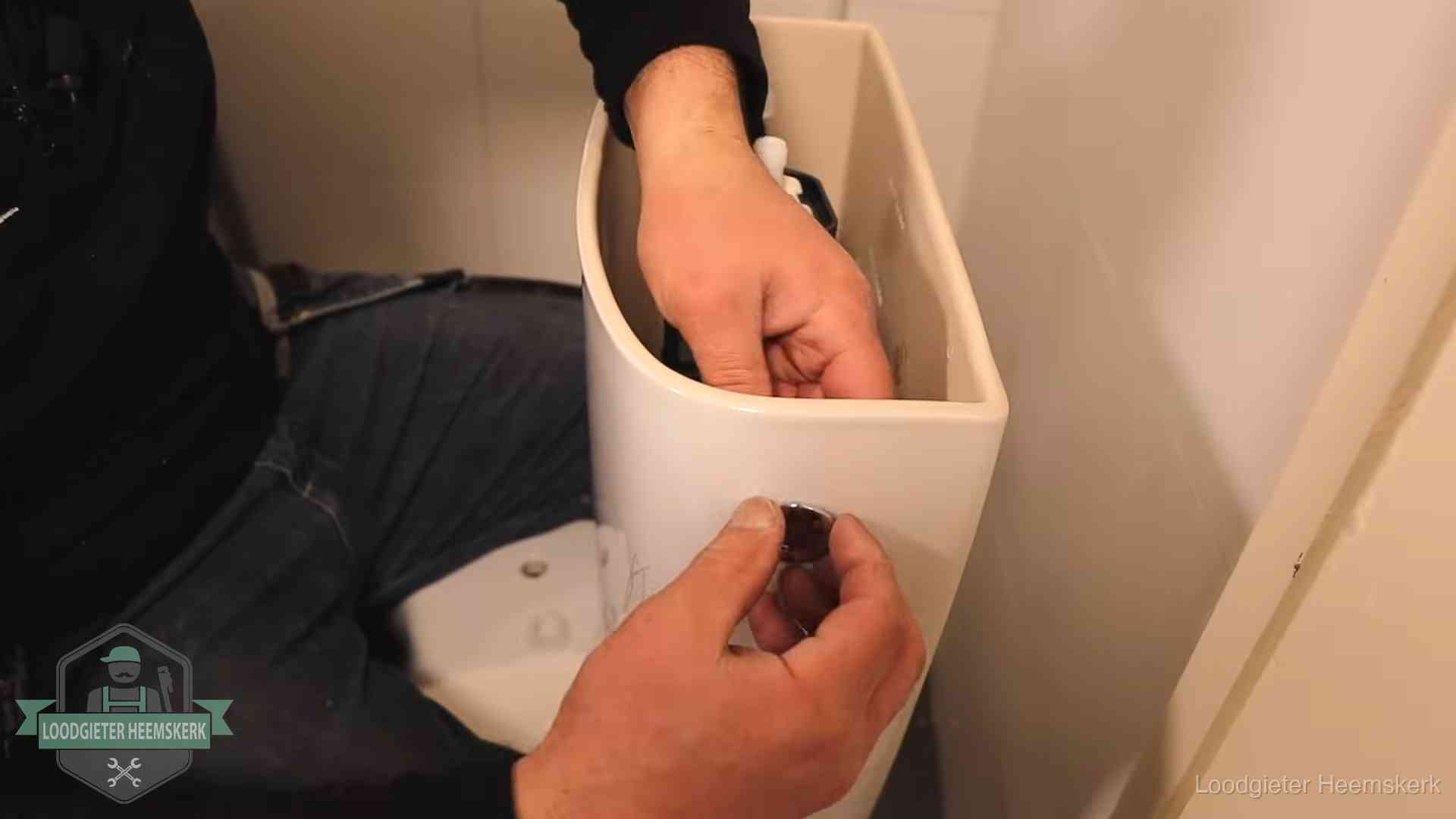 Je wc verstoppingsvrij houden in Heemskerk Drukknop van een duoblok-stortbak wordt gemonteerd bij een toilet in Heemskerk