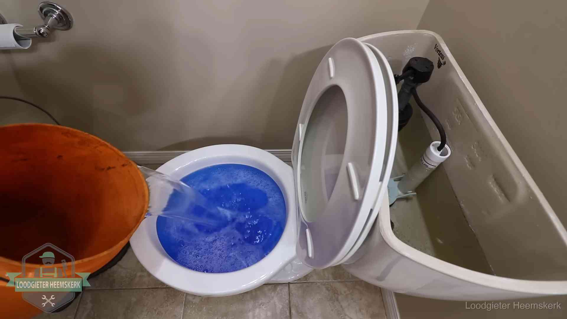 Water komt omhoog in de wc in Heemskerk Water bij de wc-pot wordt met een emmer weggewerkt om schade te beperken in Heemskerk